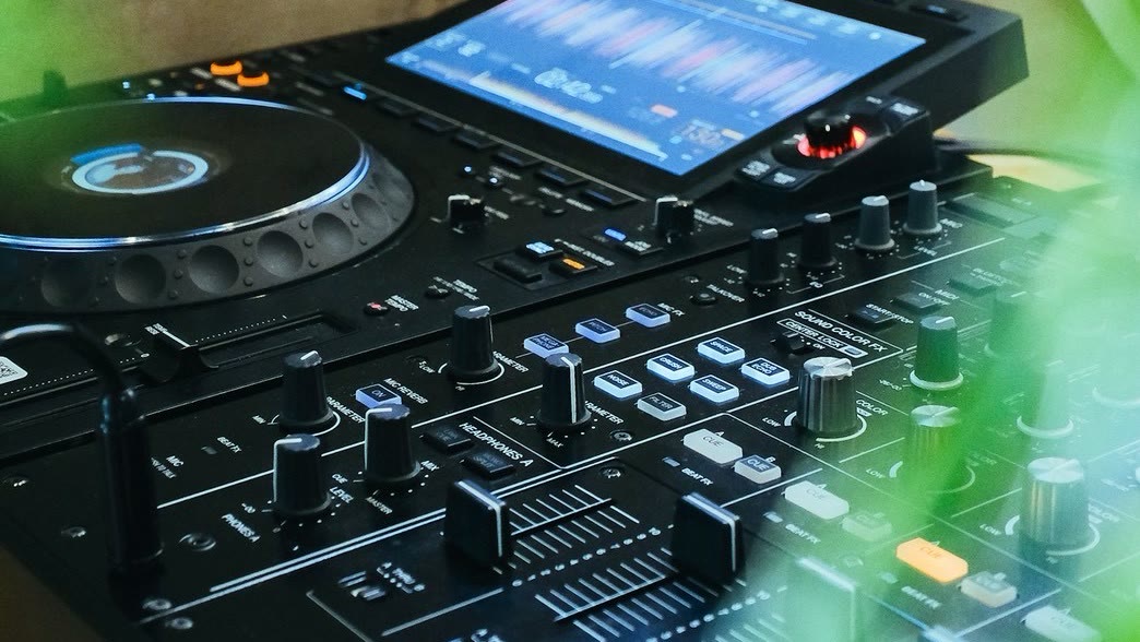 スタジオのCDJとDJミキサー。波形の出た画面と、フェーダーの並び
