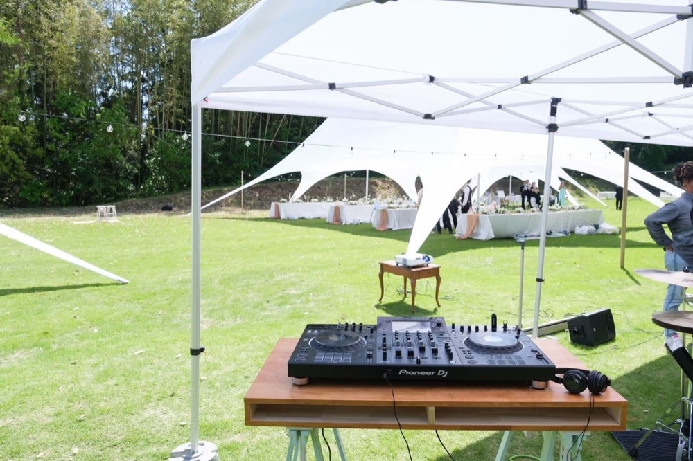 芝生のテント下に組んだDJ卓と、奥の披露宴テント
