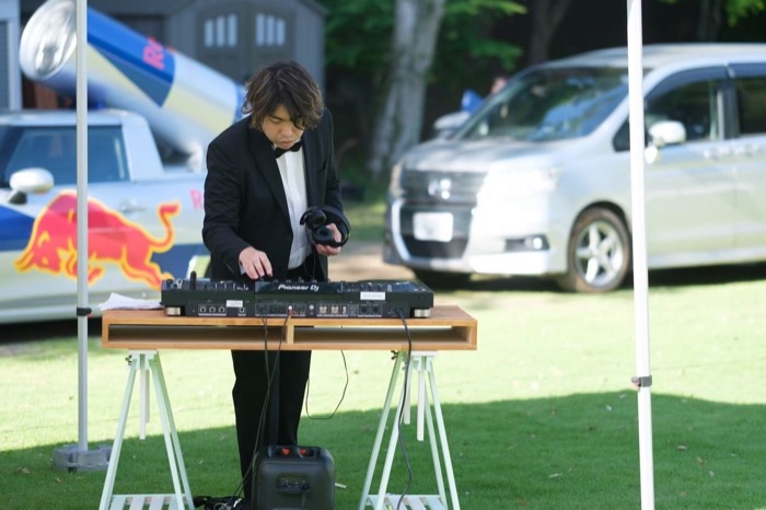 屋外でDJ機材を操作するDJ