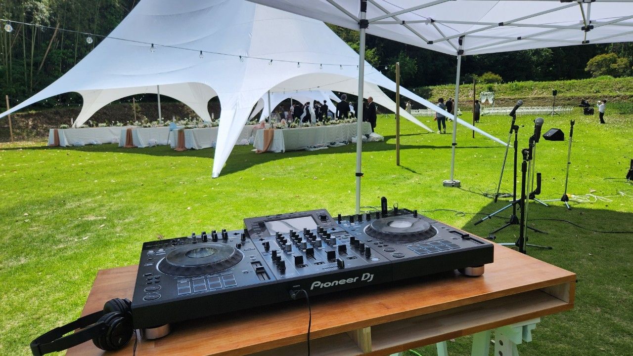 芝生に置いたDJ卓と、立ち並ぶマイクスタンド